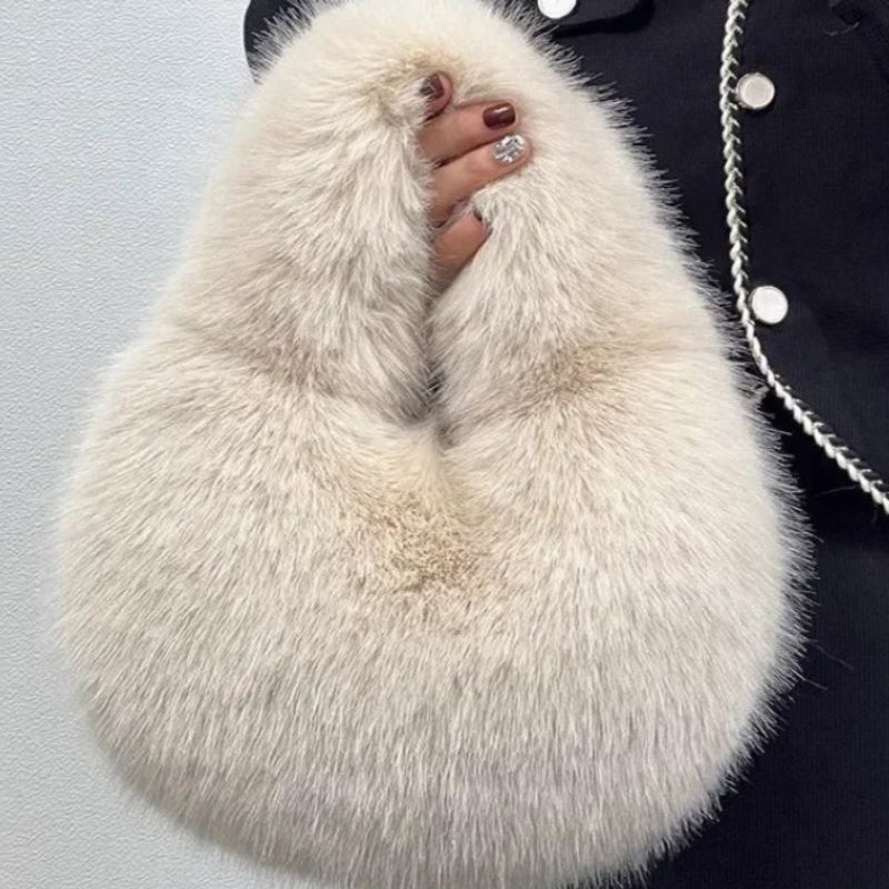 White fluffy bag held by a person wearing a dark coat with white buttons.