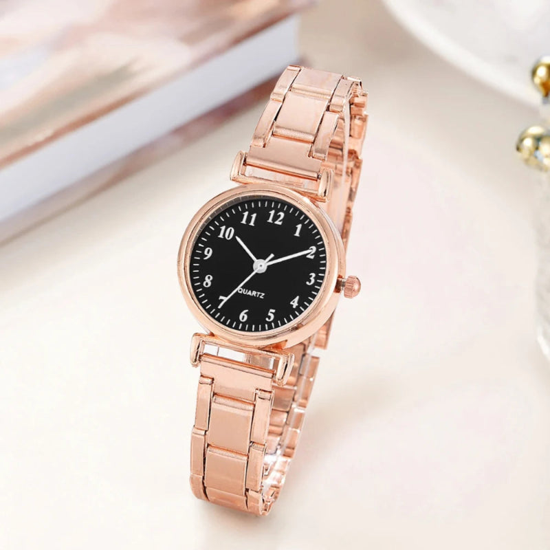 Rose gold watch with black dial on a light background