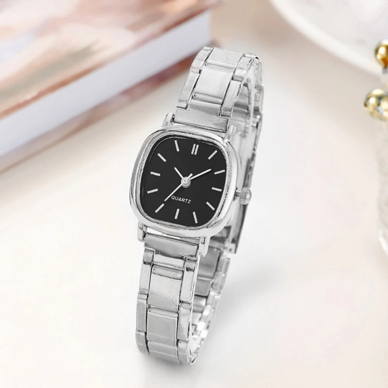 Silver watch with a black face on a light background