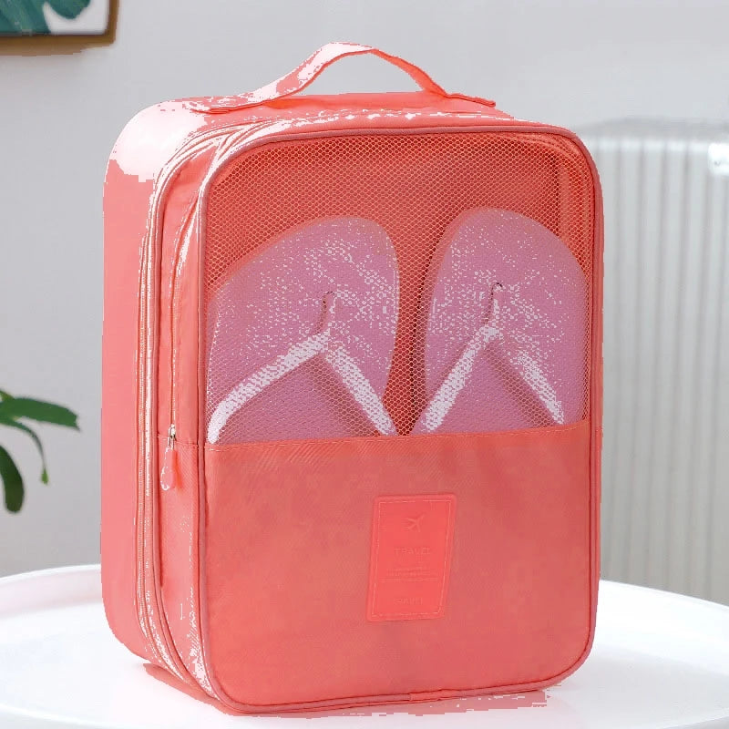 Coral-colored shoe organizer with a clear front compartment on a white surface.
