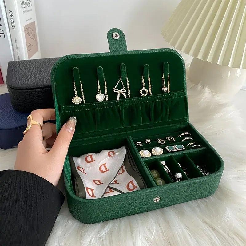 Green jewelry case with earrings and a hand holding it