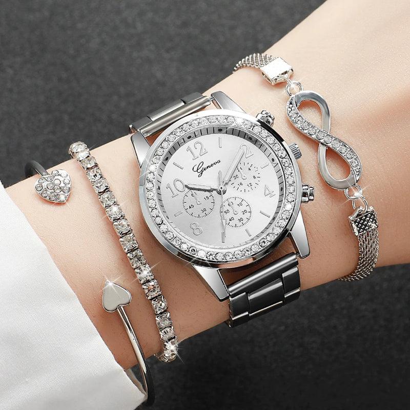 Silver watch with diamond-studded face on a wrist, wearing multiple bracelets.