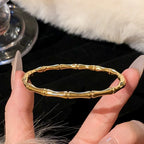 Gold bracelet on a hand with a fur surface in the background