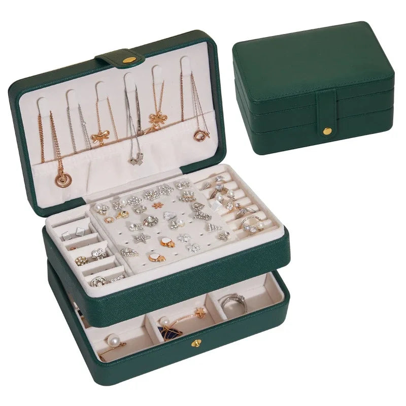Green jewelry box with jewelry displayed on a white background