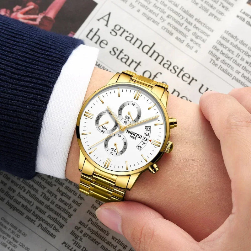 Gold wristwatch on a person's wrist with a newspaper background