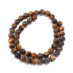 A double-strand beaded necklace made of polished tiger's eye stones, arranged in a neat circle on a clean white background.