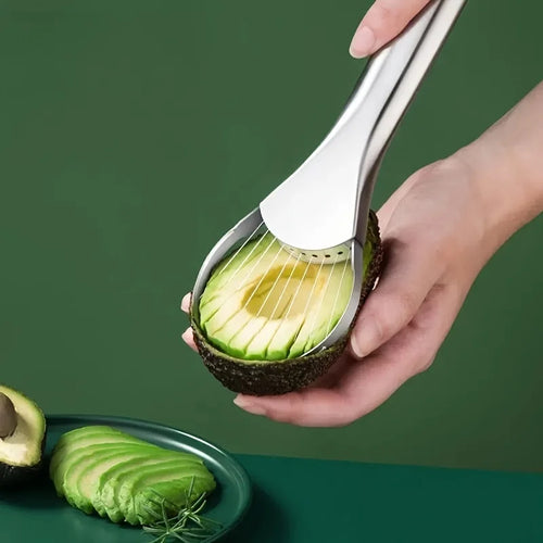 Avocado being sliced with a manual avocado slicer on a green background