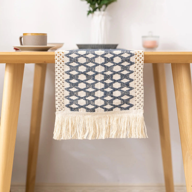 Table runner with geometric pattern and tassels on a wooden table