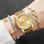 Gold watch and bracelets on a wrist against a dark background