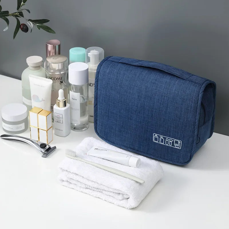 Blue toiletry bag with skincare products on a white surface