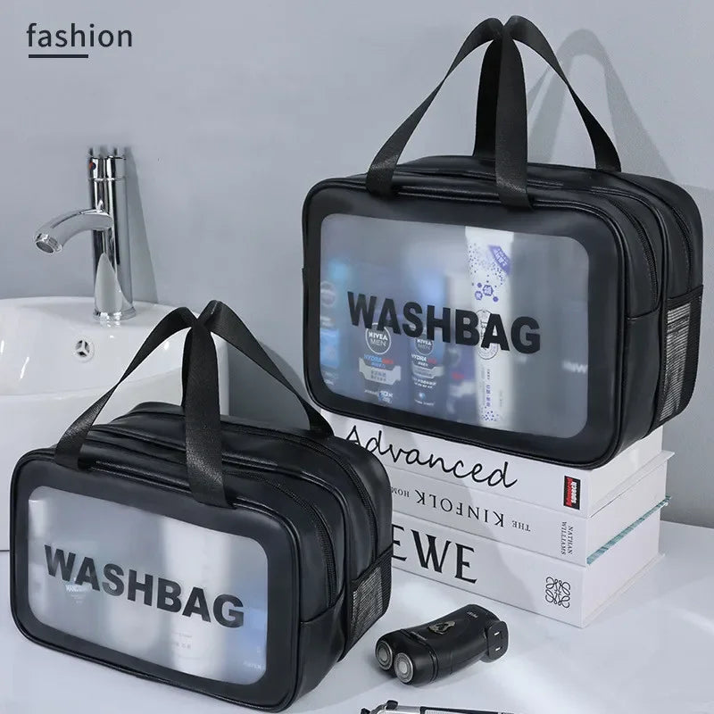 Black washbag with transparent window on a bathroom counter with books and toiletries.