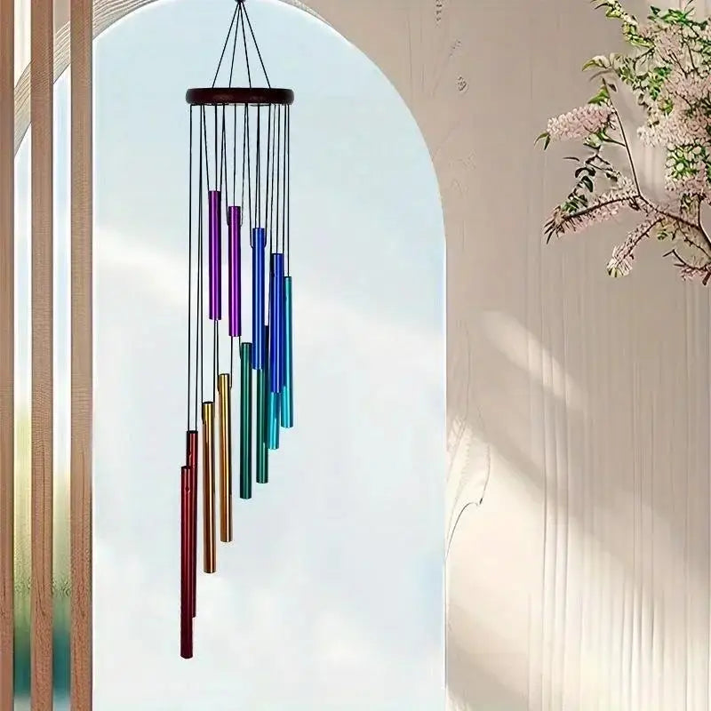 Colorful wind chime hanging against a light blue sky with a blurred background