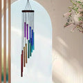 Colorful wind chime hanging against a light blue sky with a blurred background