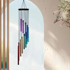 Colorful wind chime hanging against a light blue sky with a blurred background