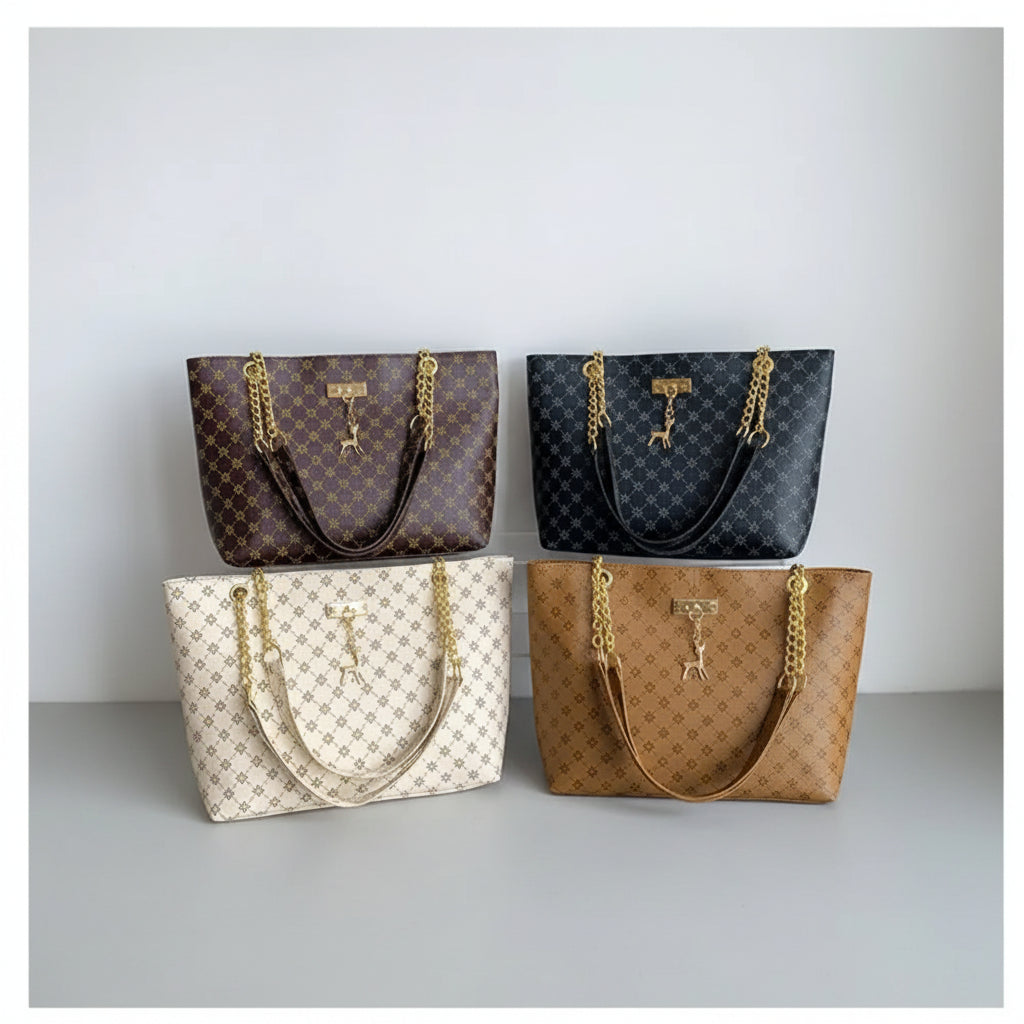 Four patterned handbags with gold chains on a black surface against a light gray wall.
