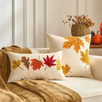 Decorative pillows with autumn leaf patterns on a couch.