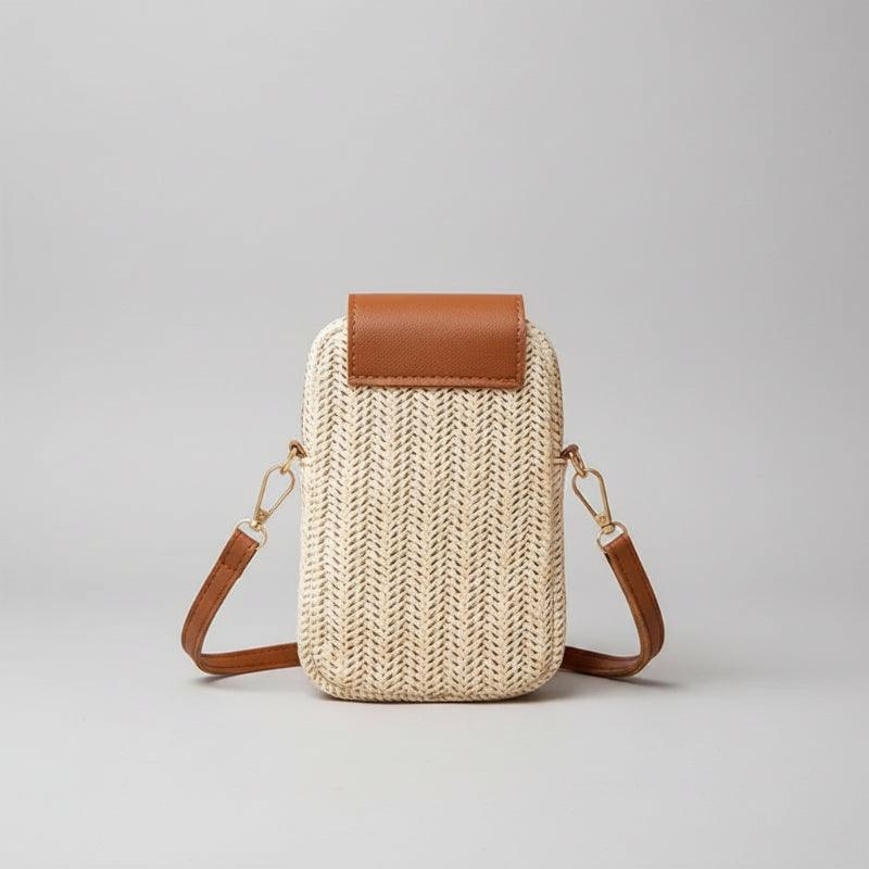 Woven handbag with brown leather accents on a wooden surface