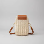 Woven handbag with brown leather accents on a wooden surface