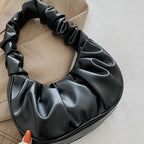 Black satin hair bun holder on a neutral background