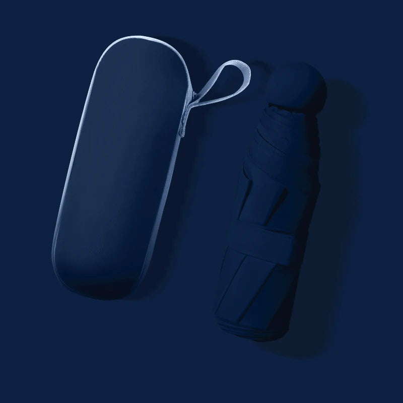 A dark navy blue retractable umbrella shown next to its matching hard case on a dark navy blue background.