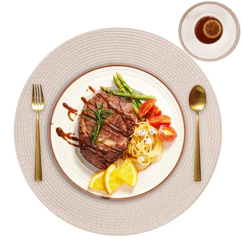 Steak with vegetables on a white plate with gold cutlery on a textured beige placemat.