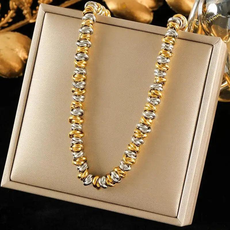Gold and silver beaded necklace on a beige jewelry box