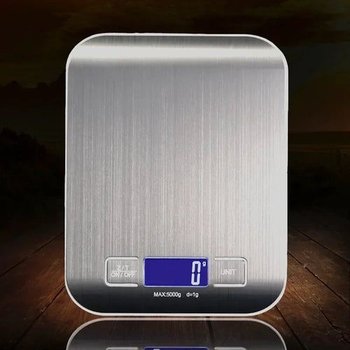 Silver digital kitchen scale on a wooden surface with a dark background