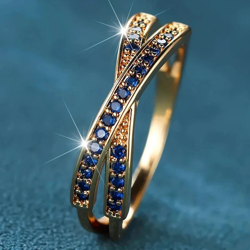 Gold ring with blue gemstones on a blue background