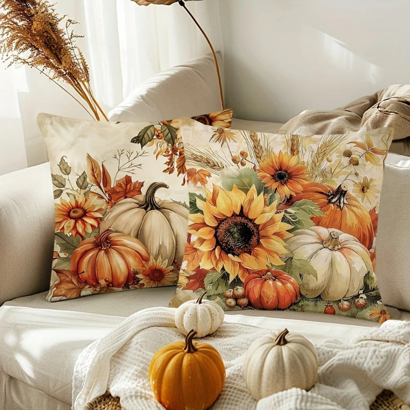 Decorative pillow with autumn-themed design featuring pumpkins and sunflowers on a couch.