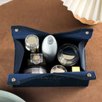 Set of glass knobs and handles in a blue leather case on a brown surface