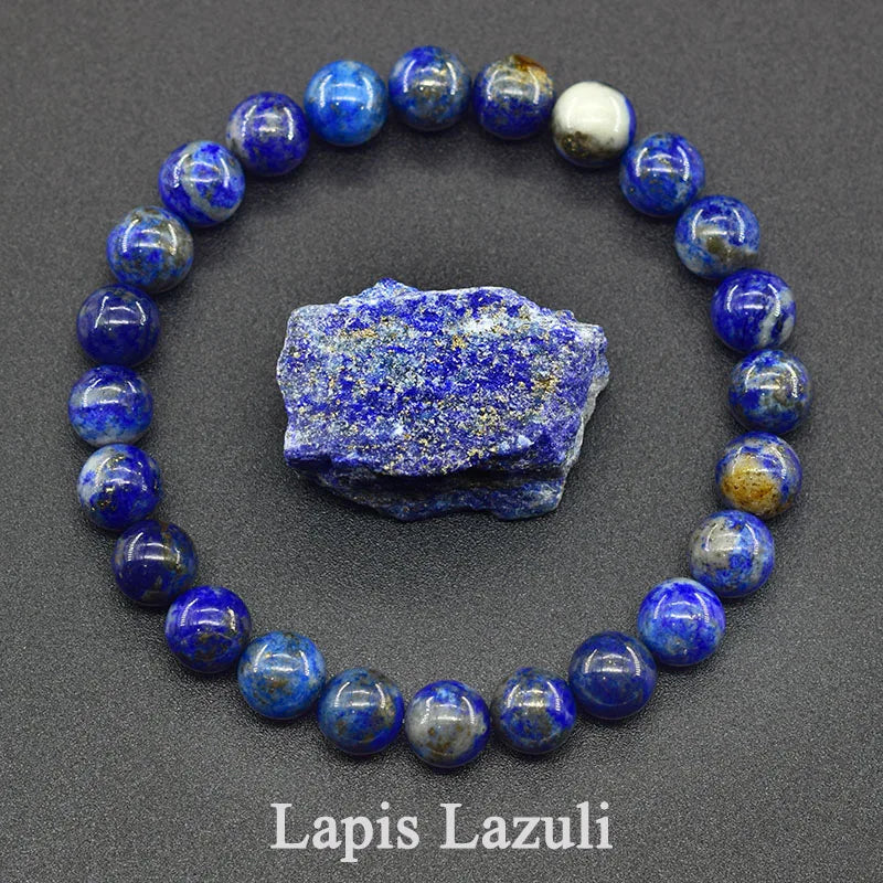 Lapis Lazuli beaded bracelet with a piece of raw lapis lazuli stone on a dark gray background.