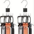Two sets of leather belts with metal hooks on a white background