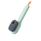 Light green scrub brush with a gray bristle head on a white background