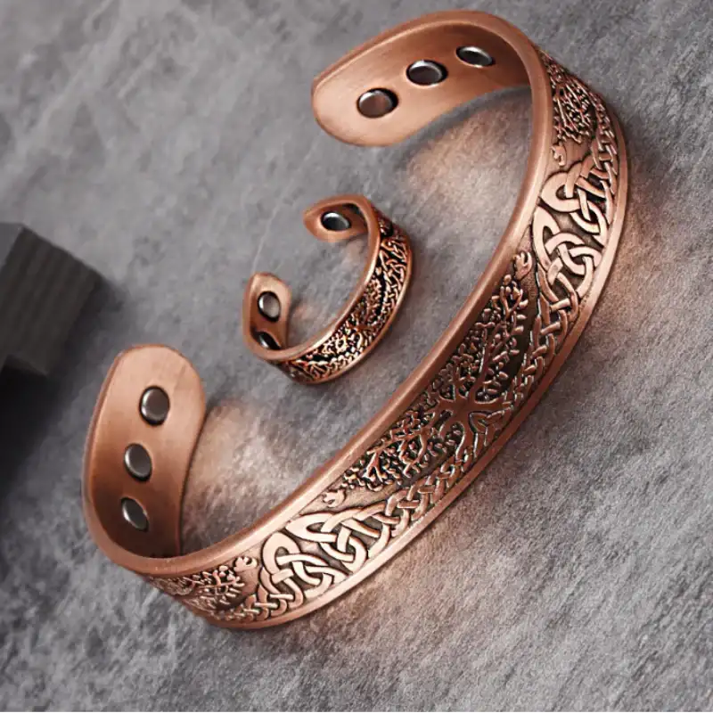 Bronze bracelet with intricate patterns on a gray surface, branded 'Vinterly'.