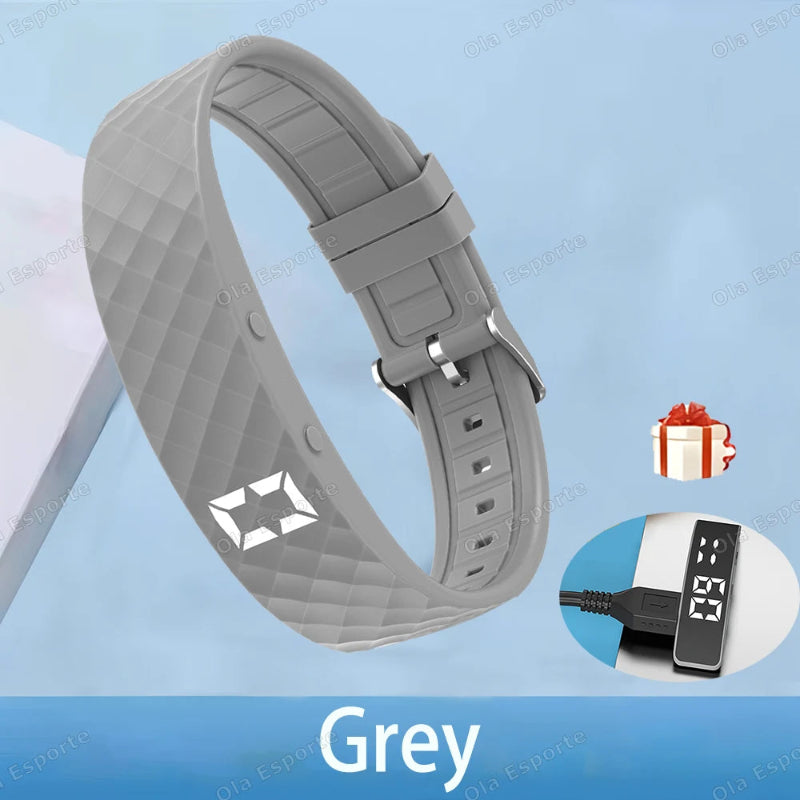Gray smartwatch band with charging cable on a blue background