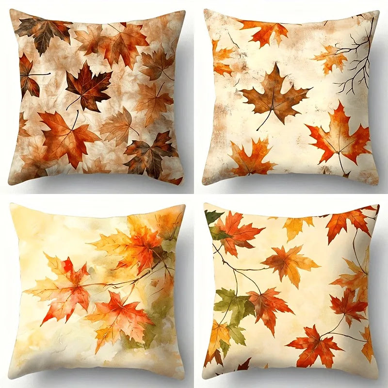 Four decorative pillows with autumn leaf patterns on a white background