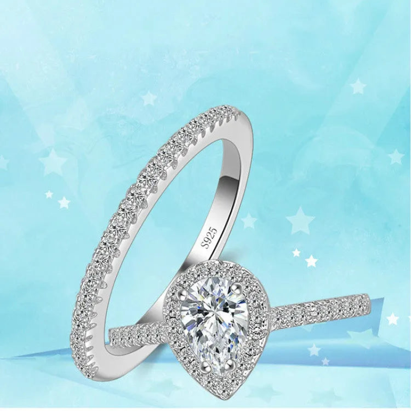 Silver ring with a heart-shaped diamond on a light blue background