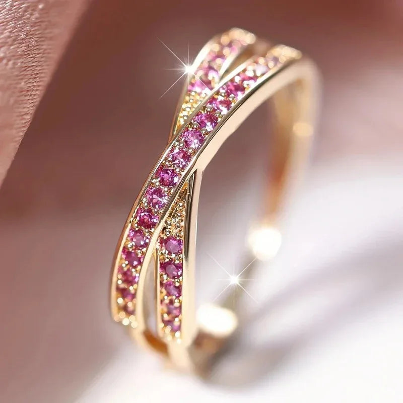 Gold ring with pink gemstones on a soft background