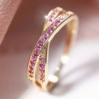 Gold ring with pink gemstones on a soft background