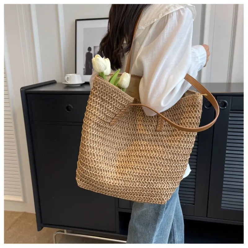 Person holding a woven bag with flowers against a neutral background