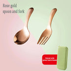 Rose gold spoon and fork set with a green lunch box on a pink and green gradient background.