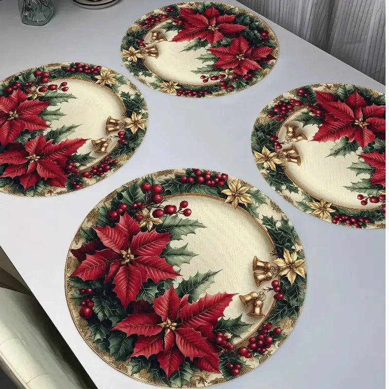 Four round holiday table placemats with a Christmas poinsettia and holly pattern, arranged on a white tabletop.
