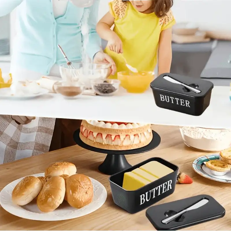 Butter container with knife on a kitchen counter, surrounded by food items.