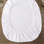 White fitted sheet on a bed with 'vave' branding.