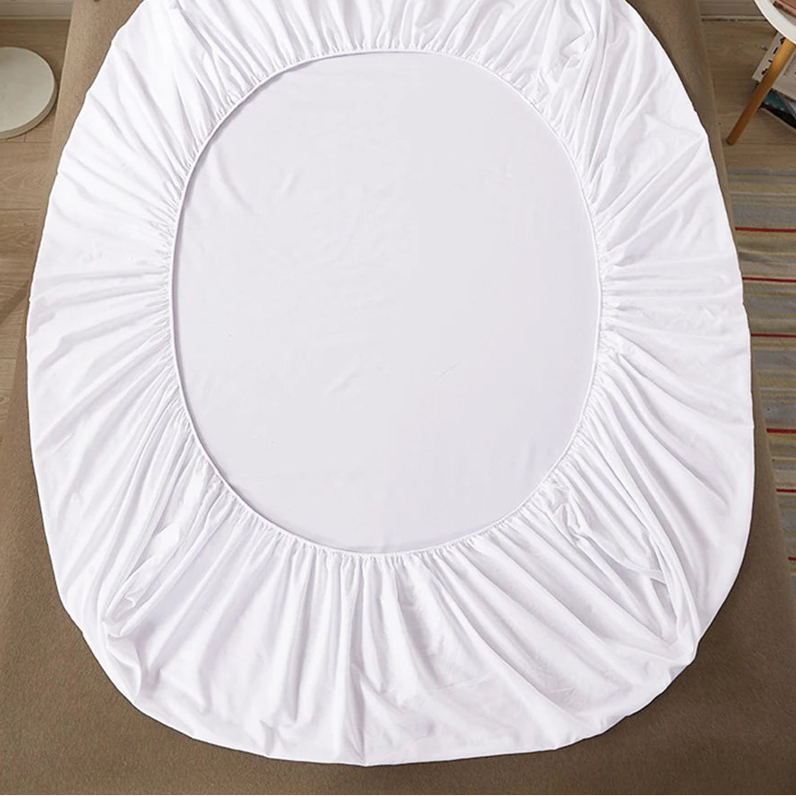 White fitted sheet on a bed with 'vave' branding.