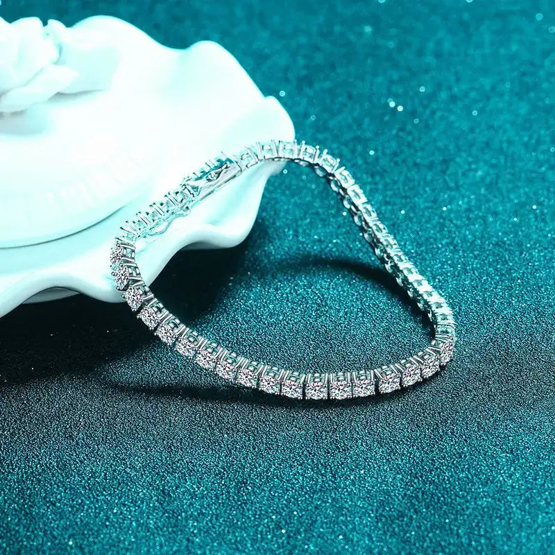 Silver bracelet with clear stones on a textured blue surface