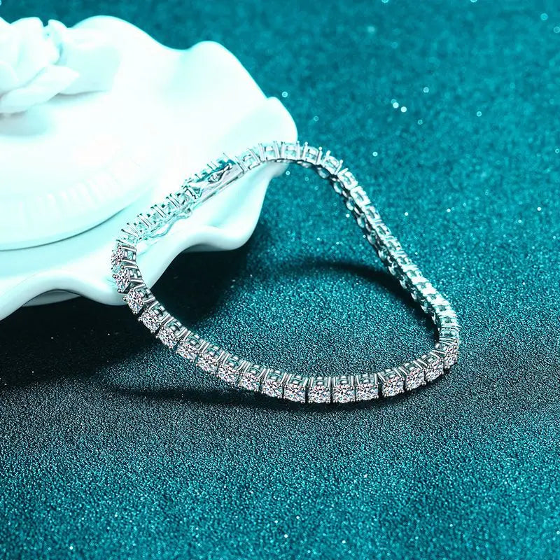 Silver bracelet with clear stones on a textured blue surface