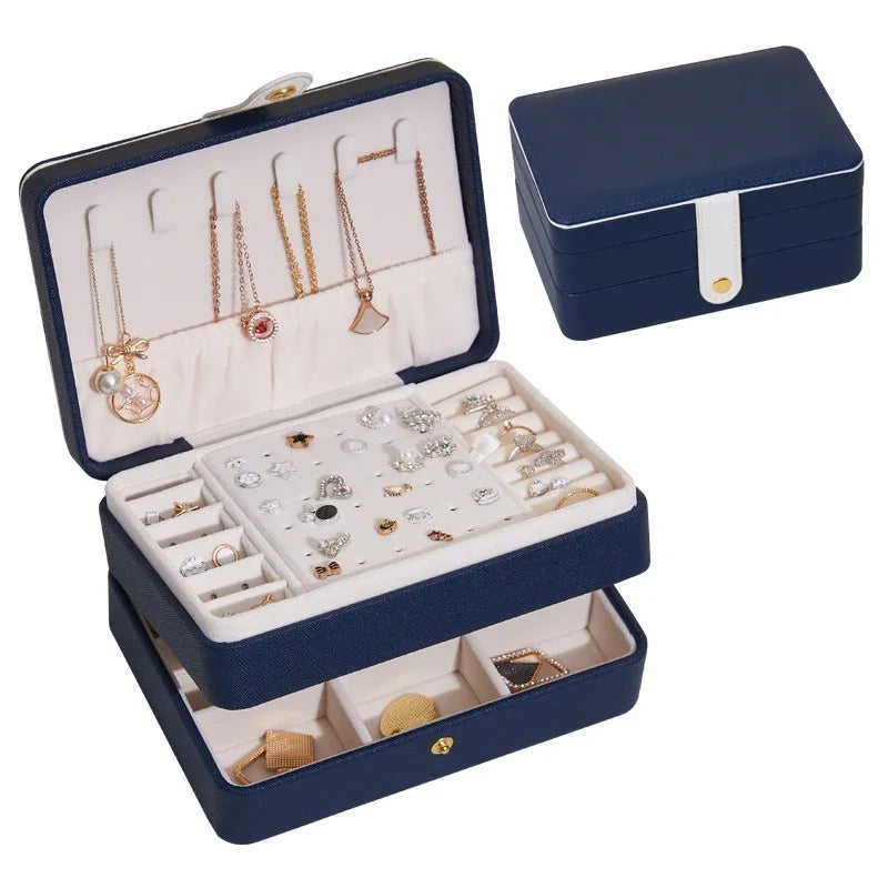 Navy jewelry box with jewelry displayed on a white background