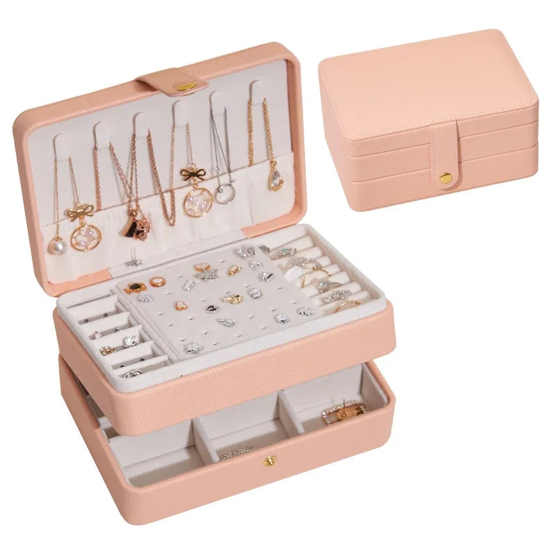 Pink jewelry box with jewelry inside on a white background