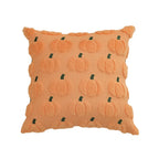 An orange textured throw pillow featuring a 3D pumpkin pattern with small dark green stems, set against a plain white background.